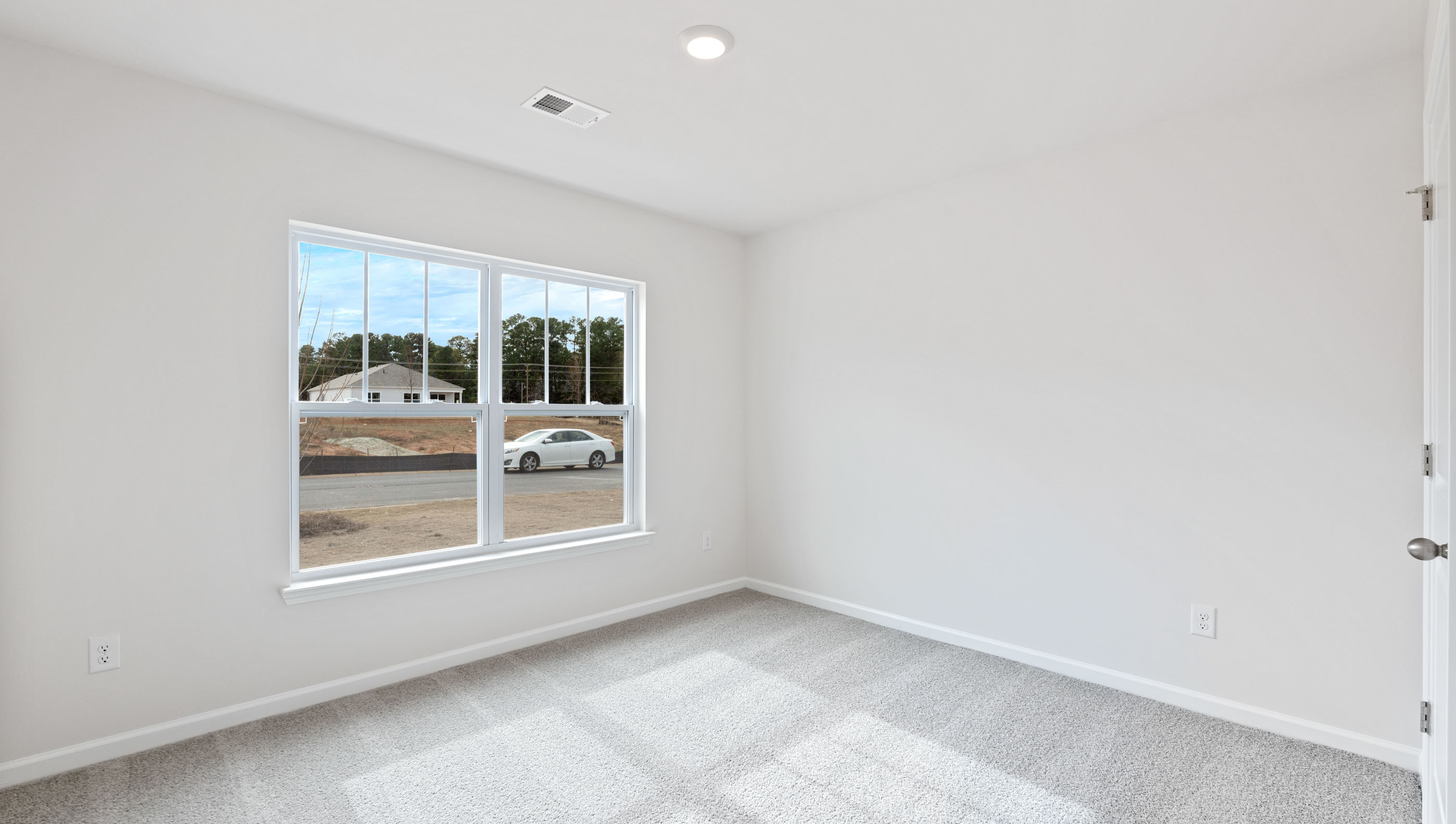 Bedroom with carpet and windows.a