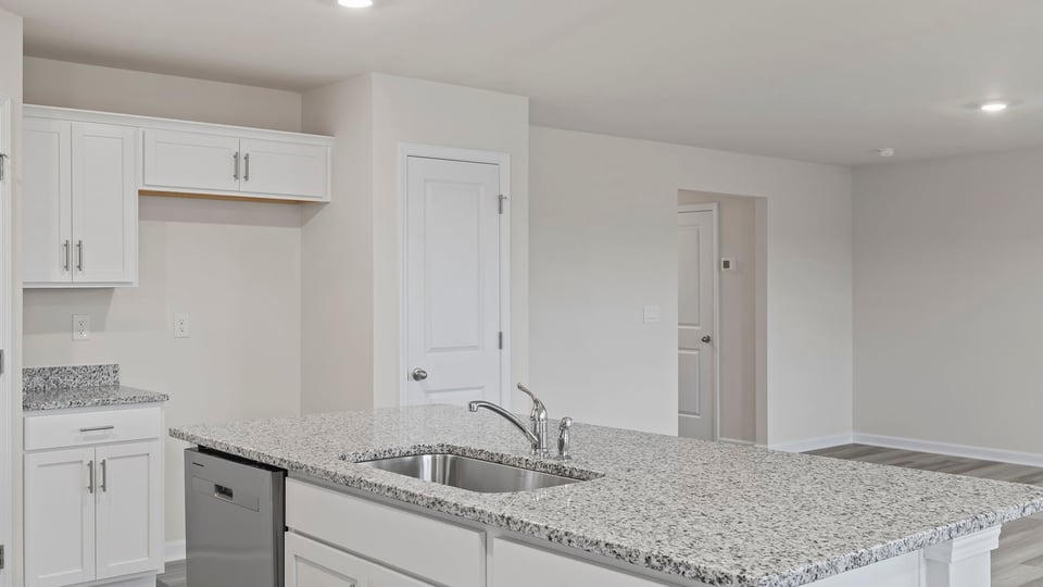 Kitchen island hosts the sink and dishwasher.