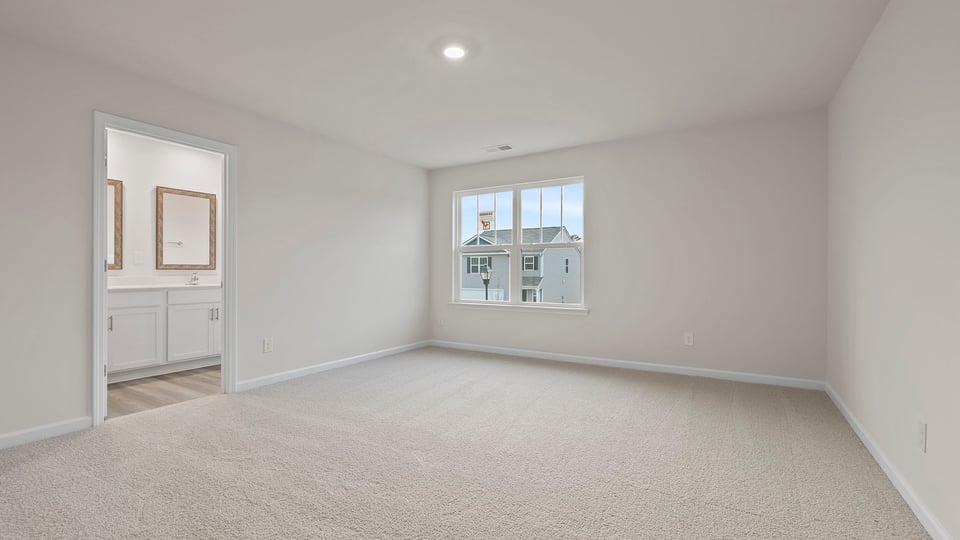 Primary bedroom with large window and carpet.