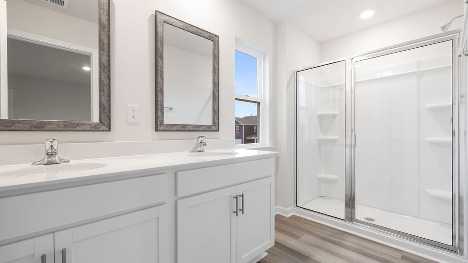 Primary bath with dual sink vanity and walk-in shower.