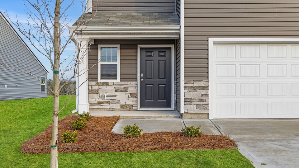 Inviting covered porch with stone accents.