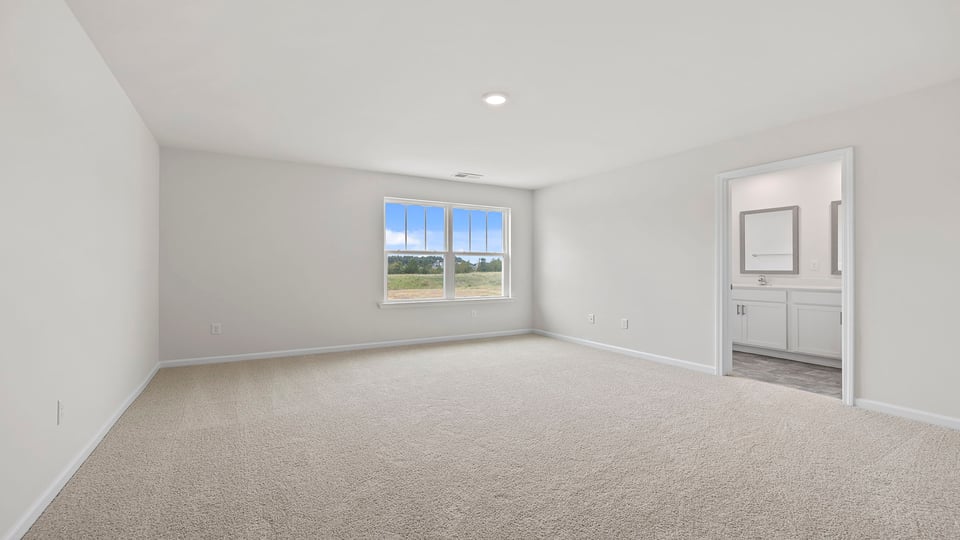 Primary bedroom with window and carpet.