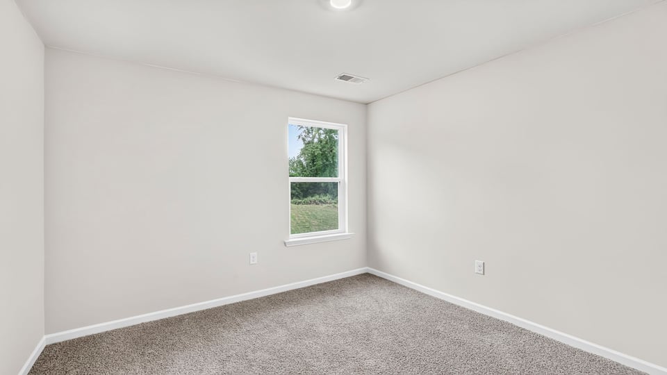 Bedroom with carpet and windows.