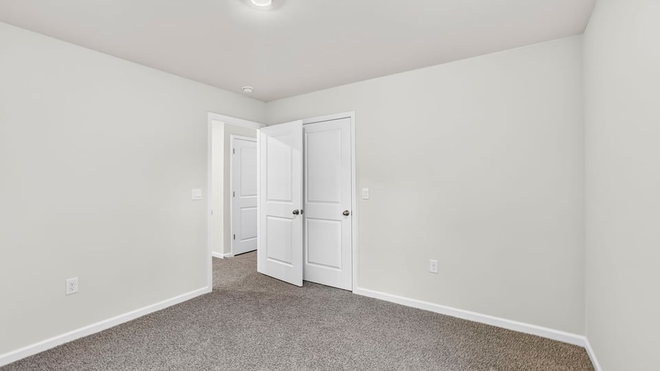 Bedroom with carpet and windows.