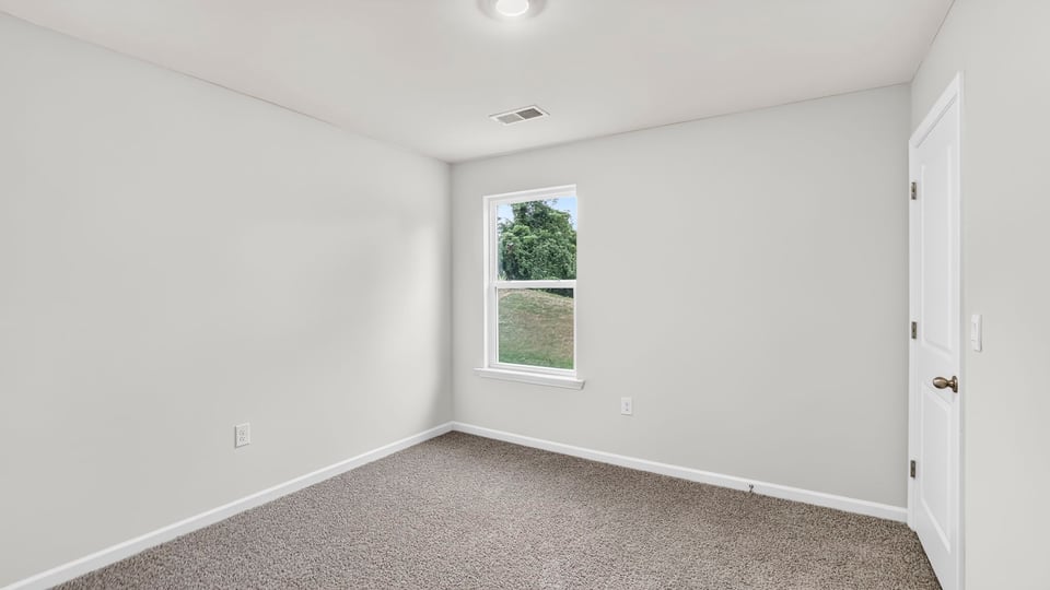 Bedroom with carpet and windows.