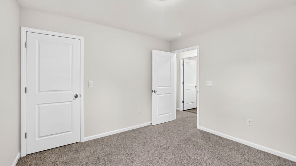 Bedroom with carpet and windows.