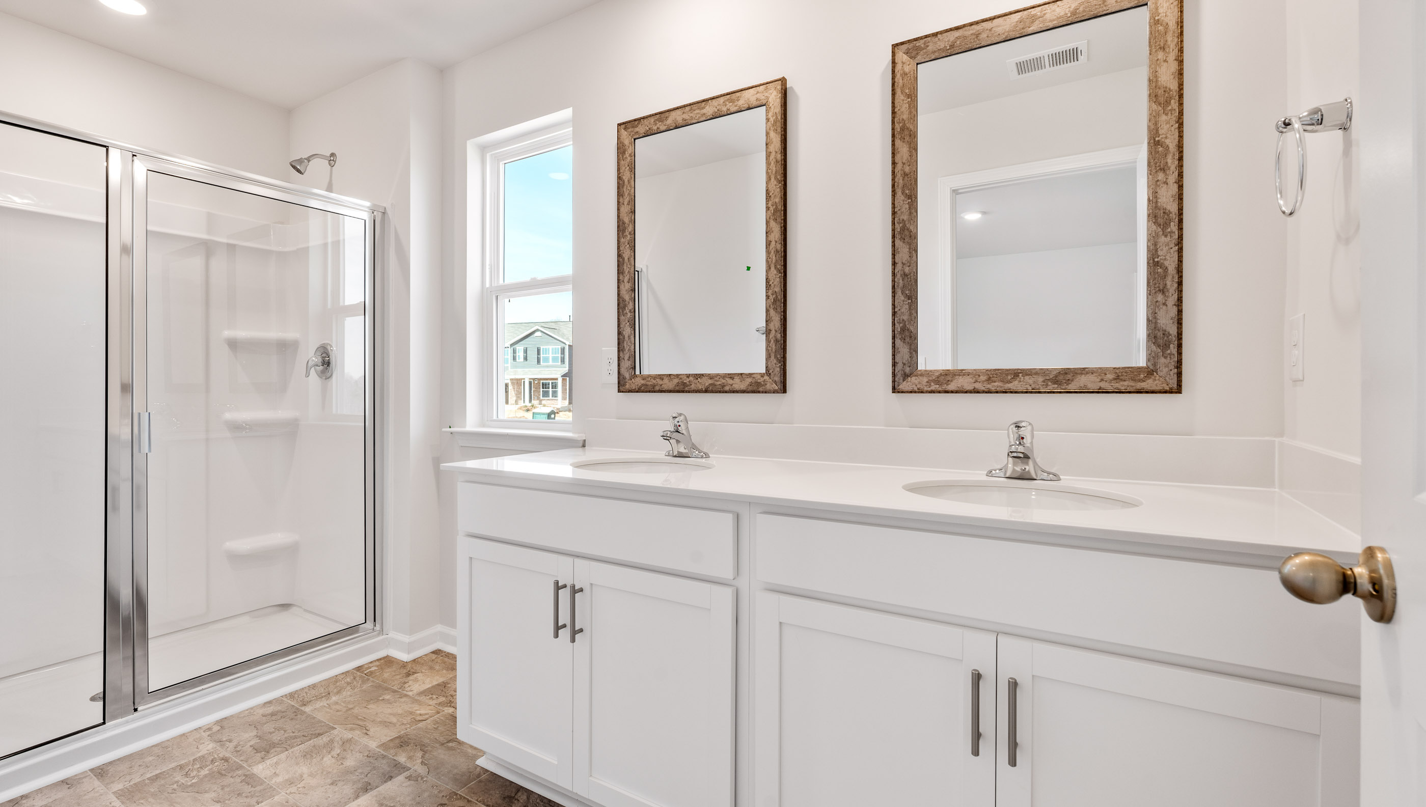 Bathroom with double vanity sink and walk in shower.