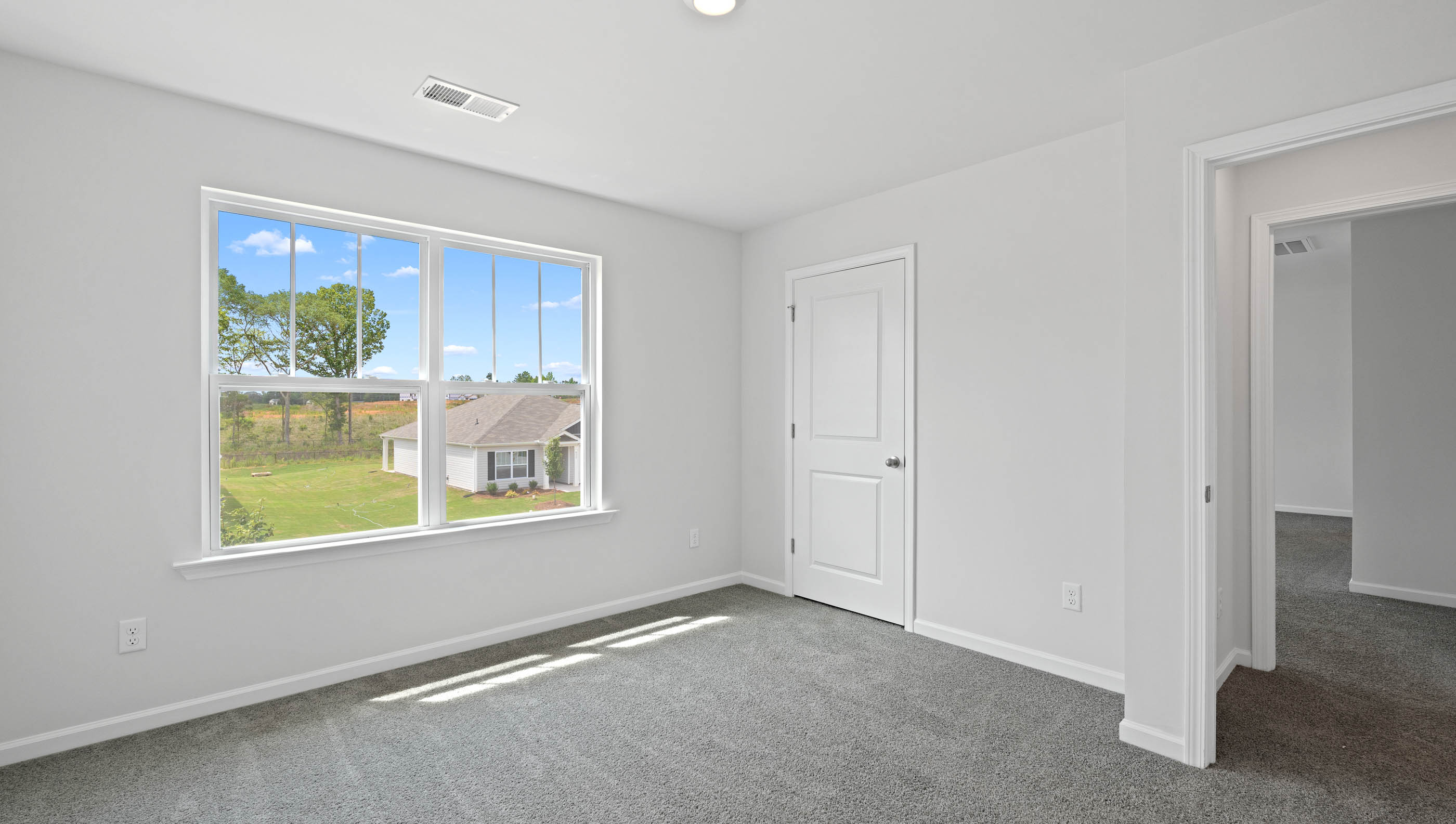 Bedroom with carpet and windows.