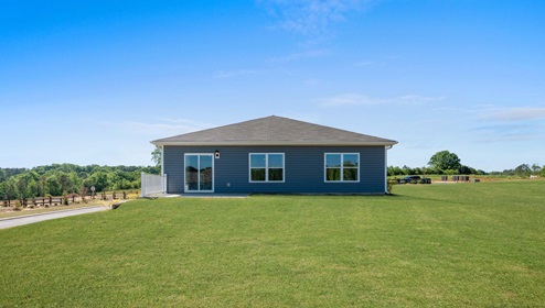 Back exterior of home with large backyard.