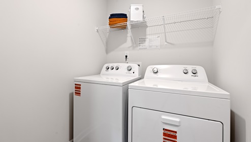 Laundry room with hanging storage racks.