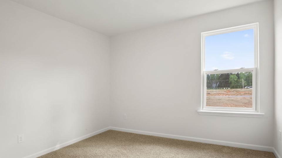 Bedroom with carpet and windows.