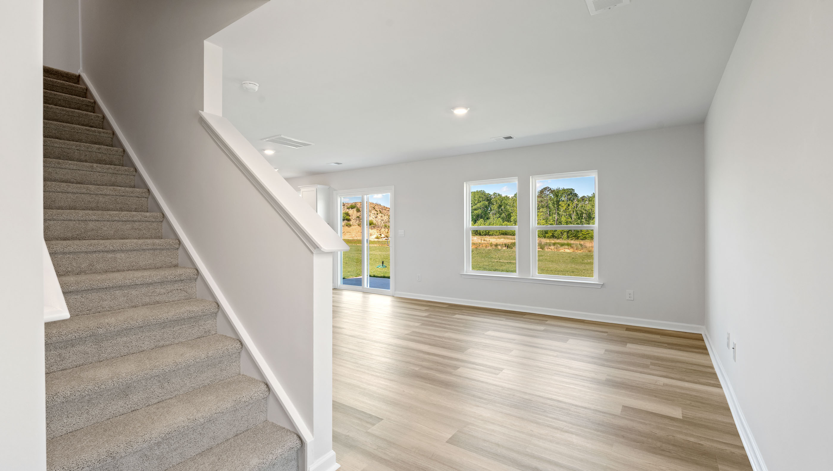 Stairs and living area with windows.
