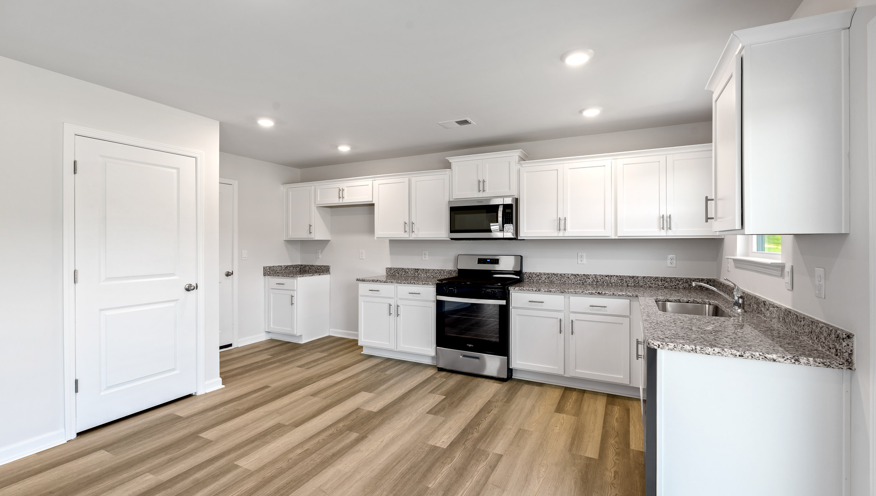 Kitchen and living area with windows.