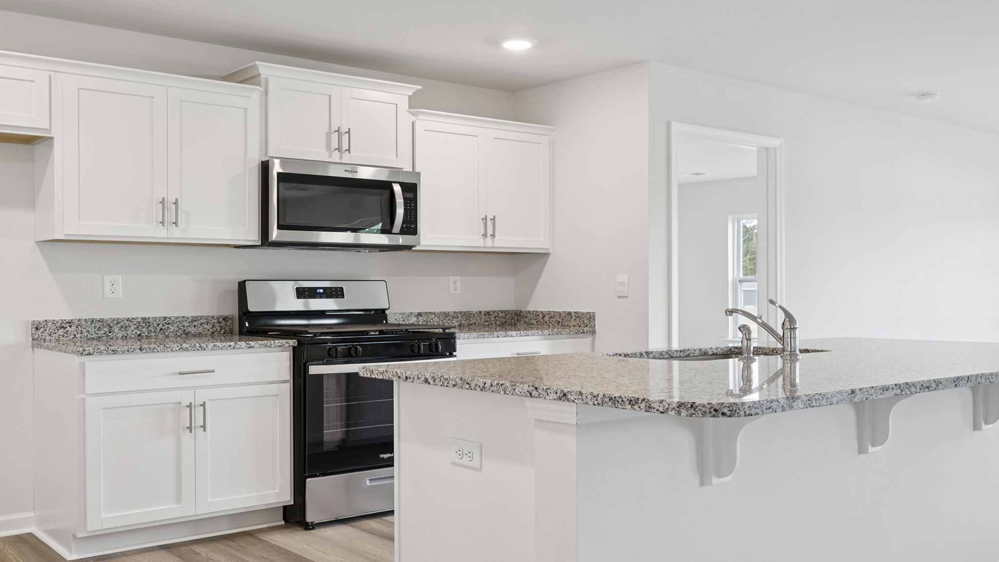 Kitchen with island and white cabinets.