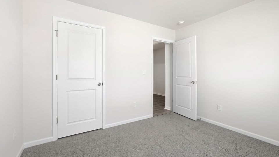 Bedroom with carpet and windows.