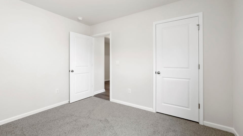 Bedroom with carpet and windows.