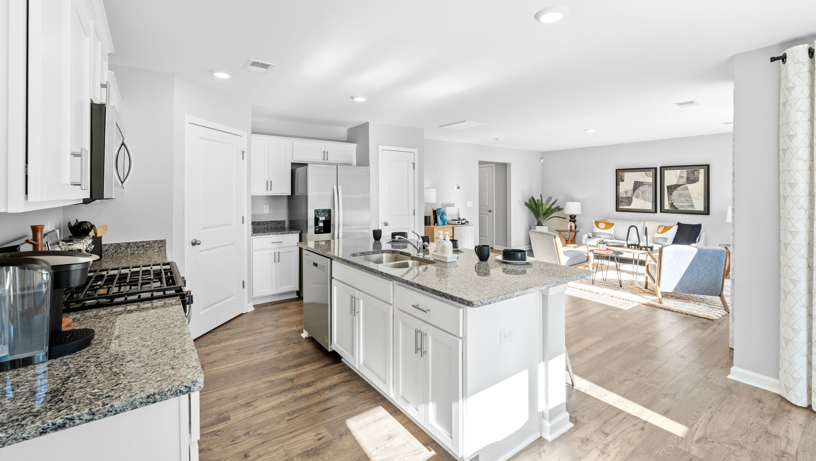 Kitchen and island with white cabinets.