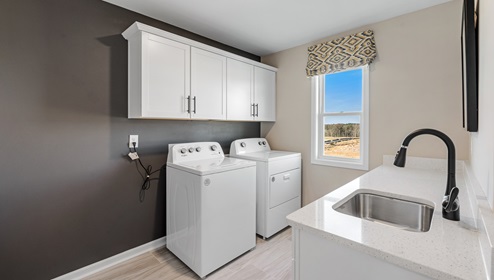 Laundry room with storage cabinets.
