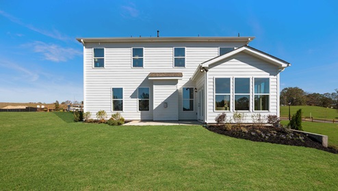 Back exterior of home with large backyard.