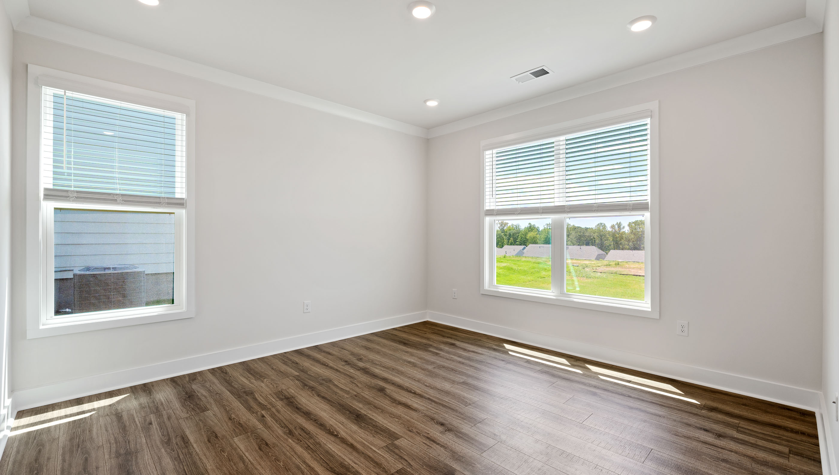 Primary bedroom with large windows.