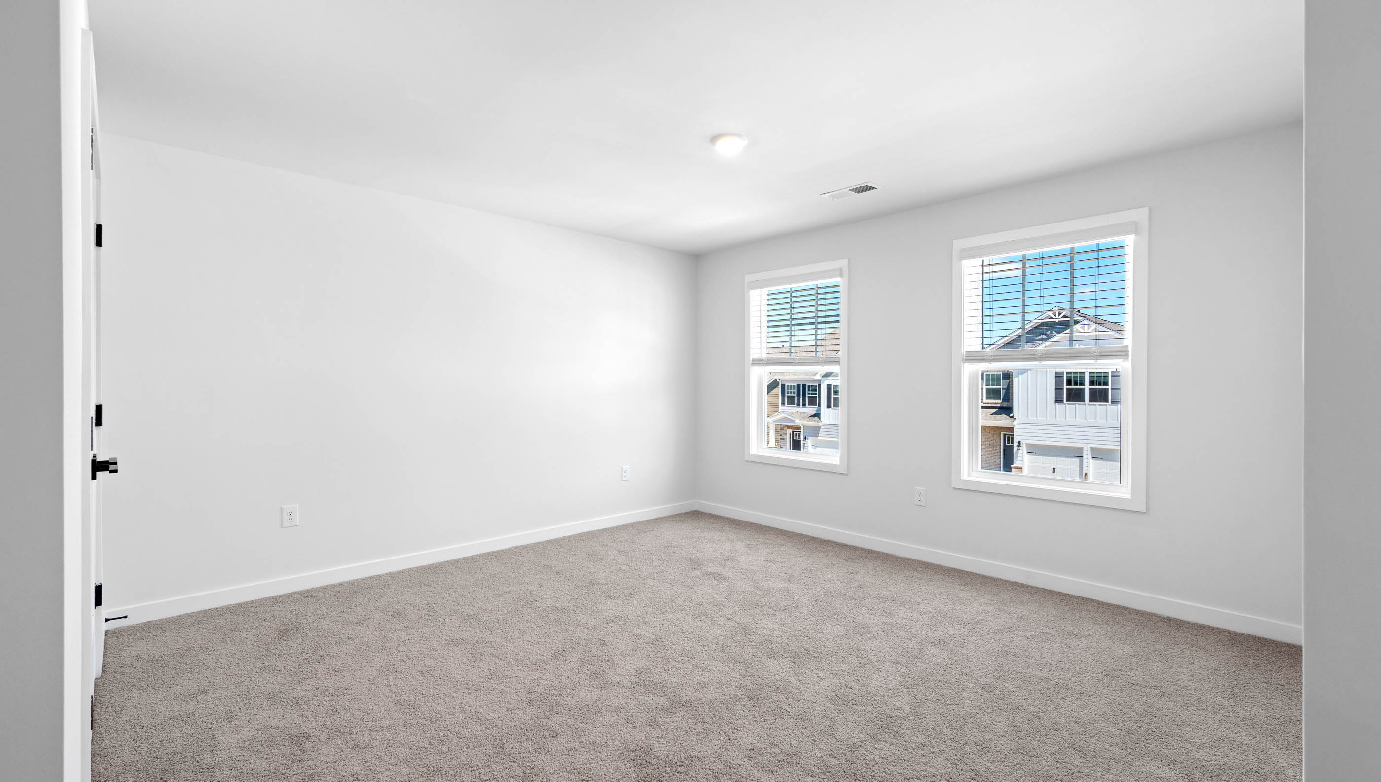 Bedroom with windows and carpet.