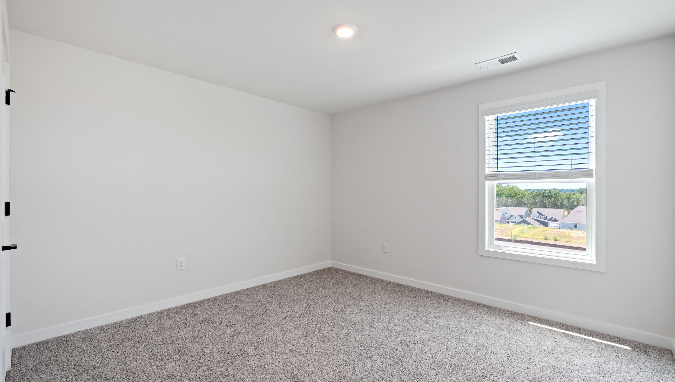 Bedroom with windows and carpet.