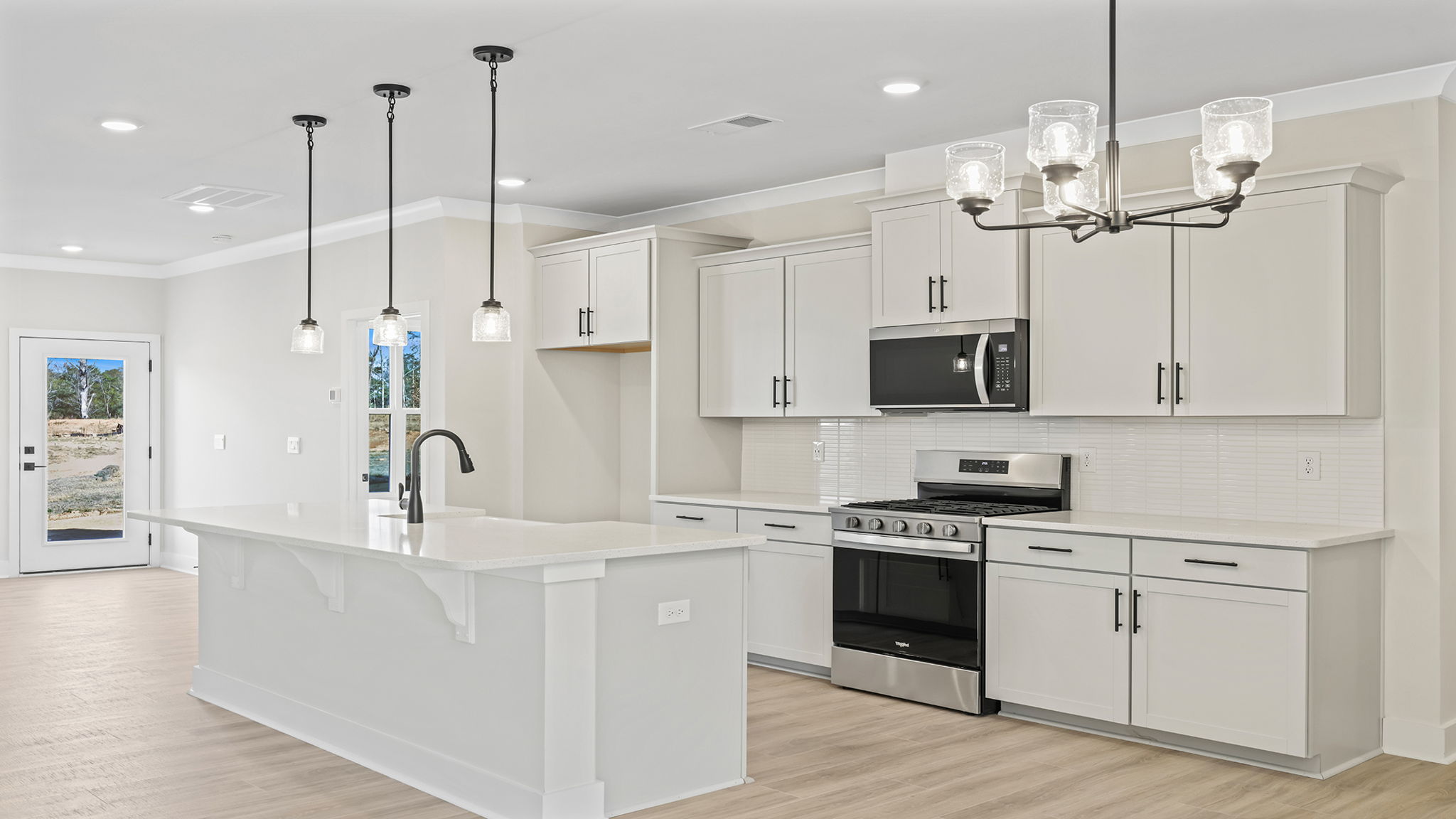 Gourmet kitchen with quartz countertops and pendulum lighing.