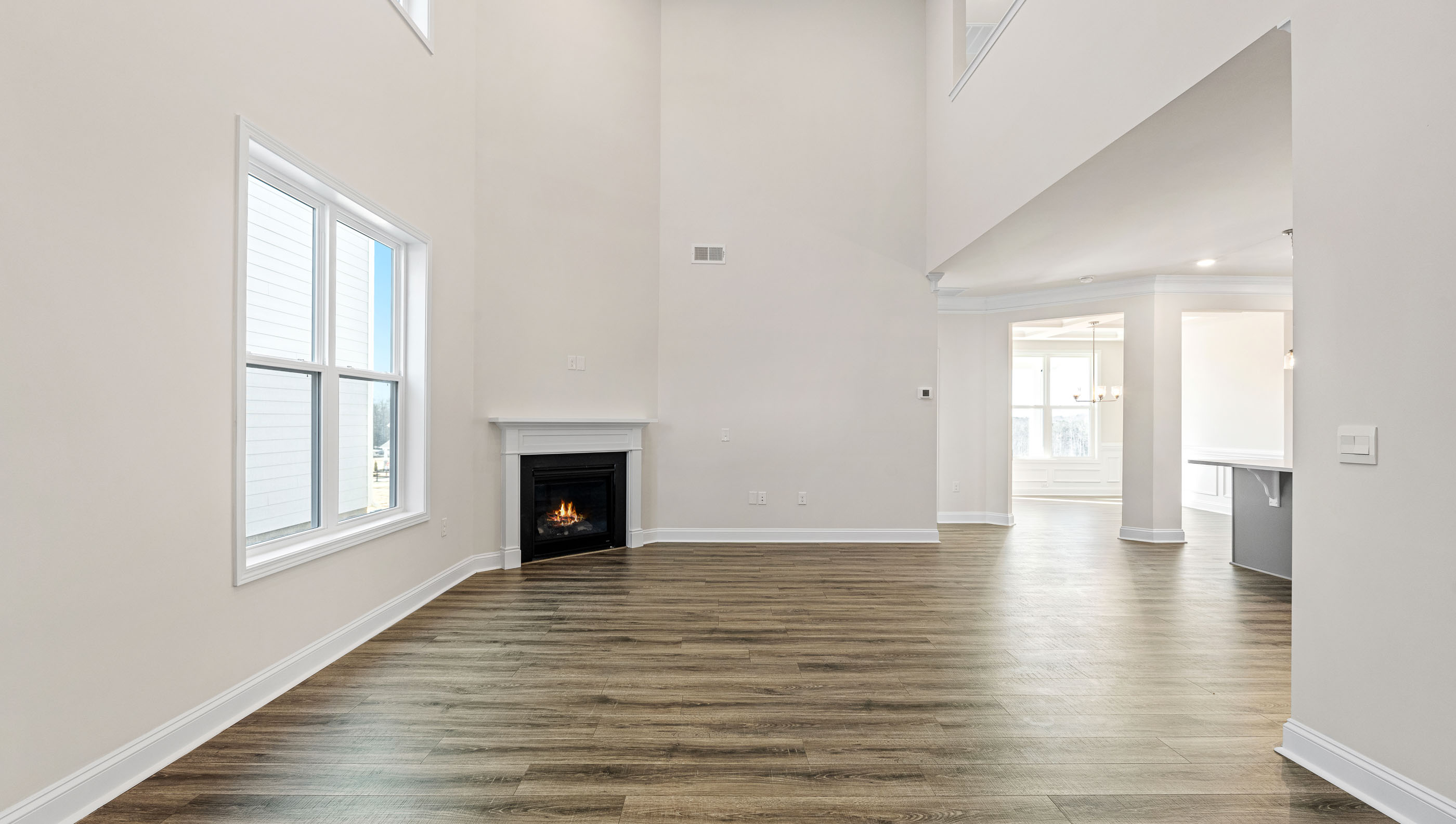 Two story living room with fireplace and windows.