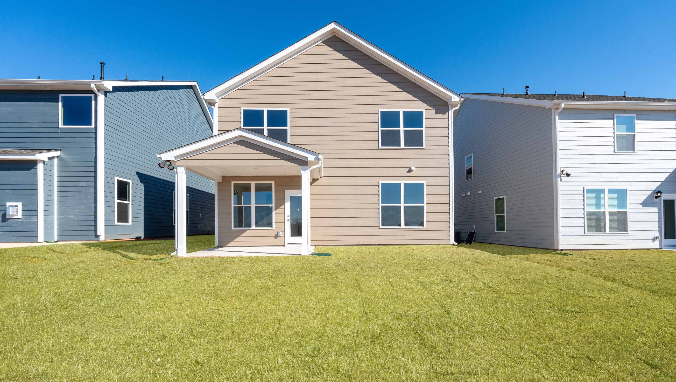 Back exterior of home with large backyard.