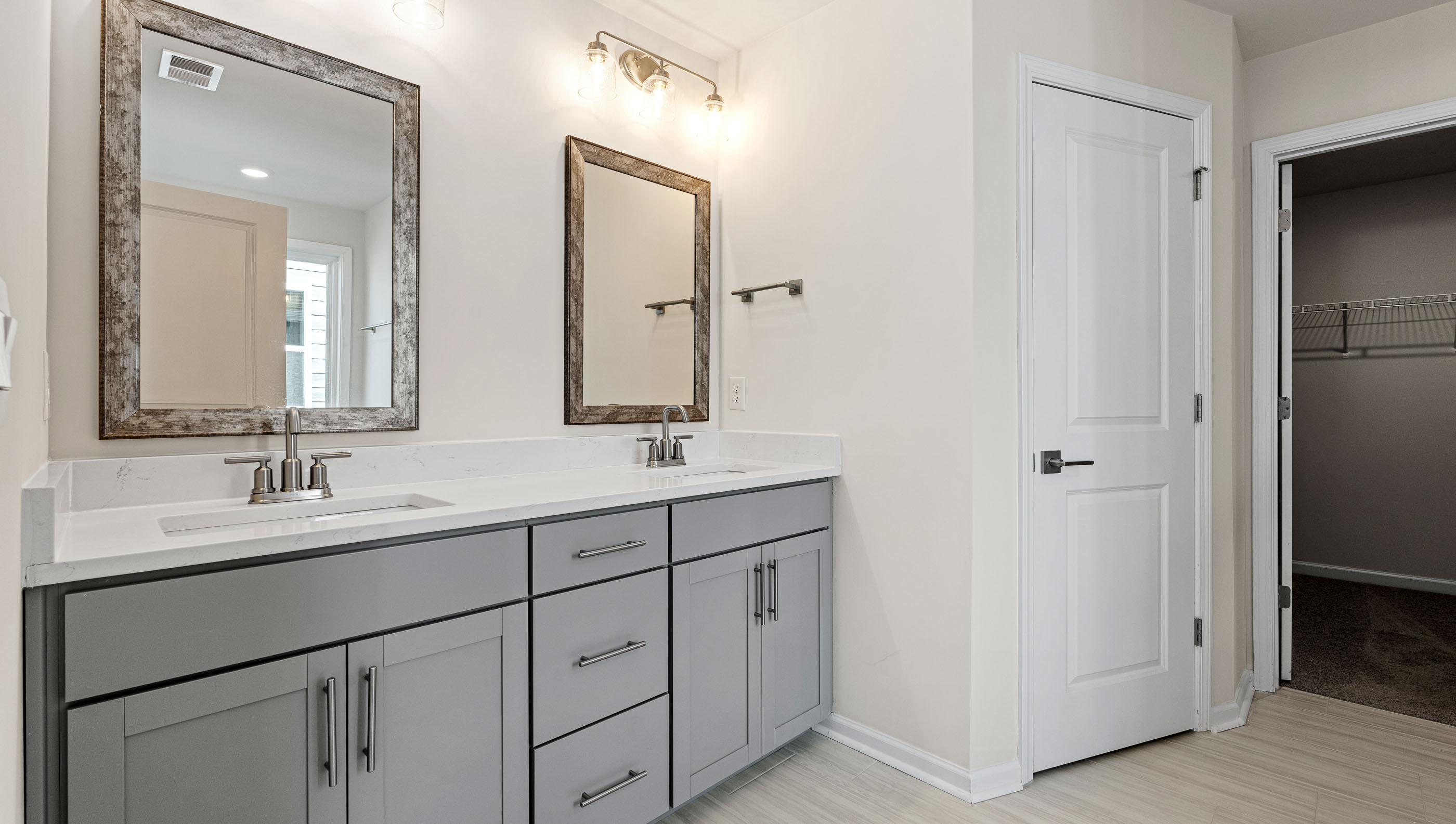 Bathroom with double vanity sink and walk in closet.