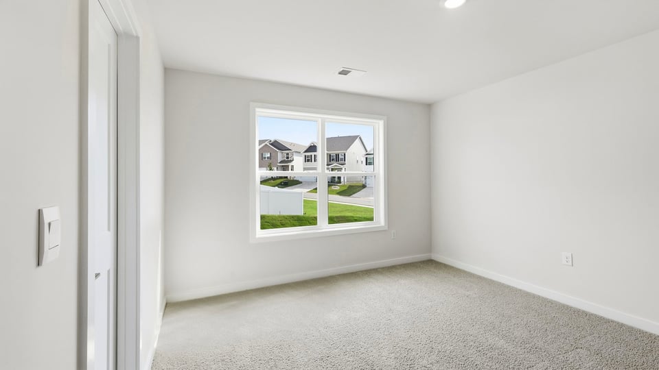 Bedroom with carpet and windows.