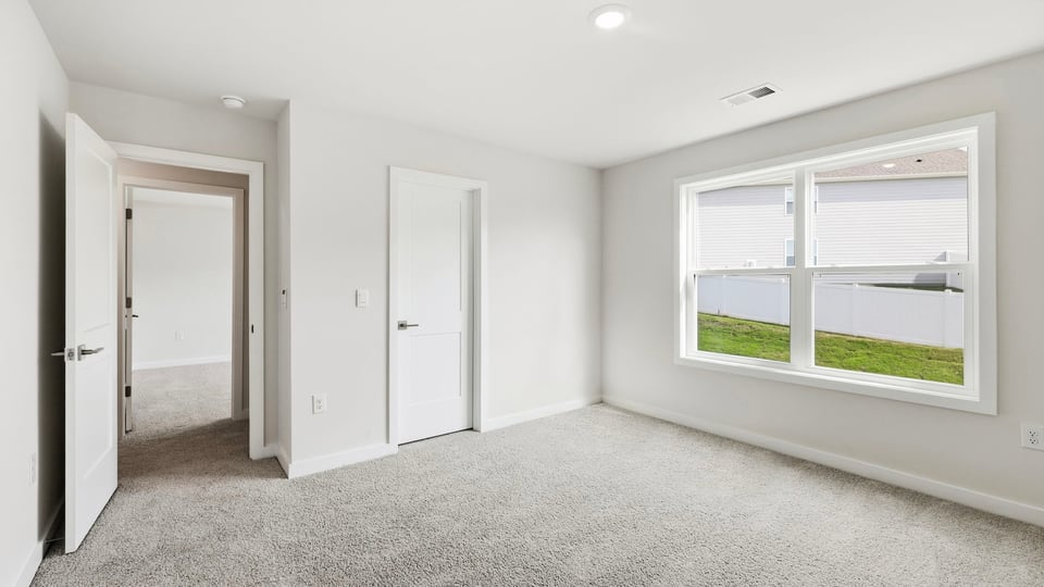 Bedroom with carpet and windows.