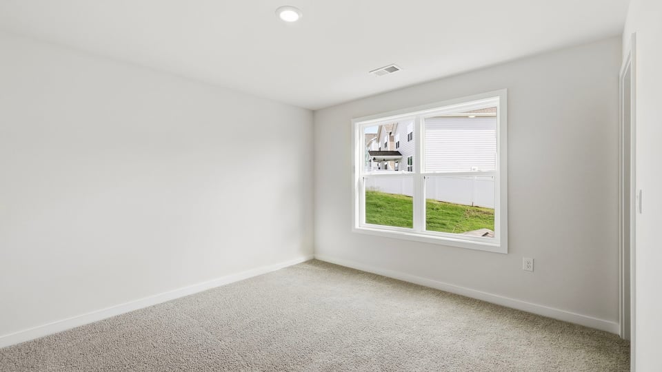 Bedroom with carpet and windows.