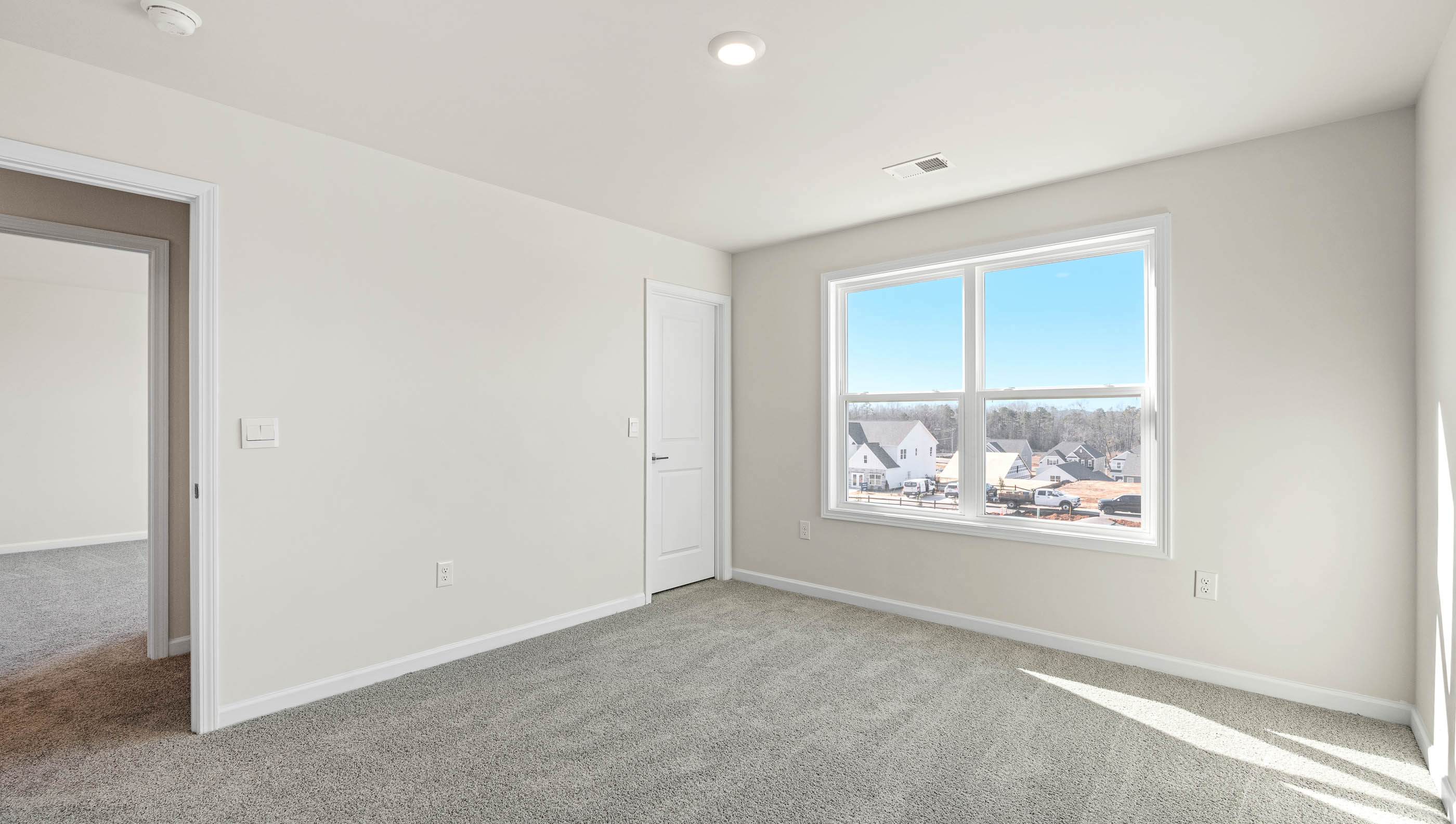 Bedroom with carpet and windows.
