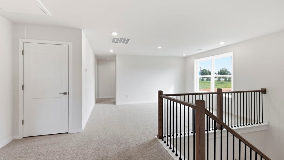 Loft area with windows and carpet.