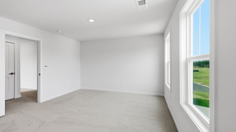 Bedroom with carpet and windows.