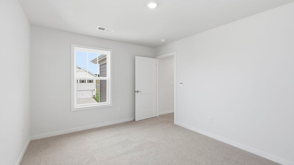 Bedroom with carpet and windows.