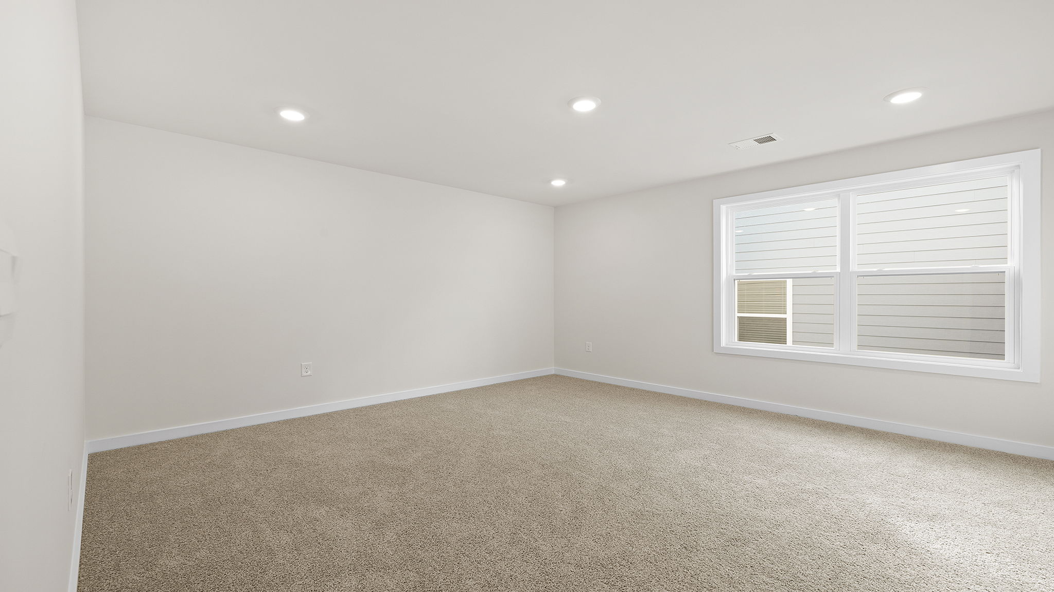 Bedroom with two large windows and carpet.