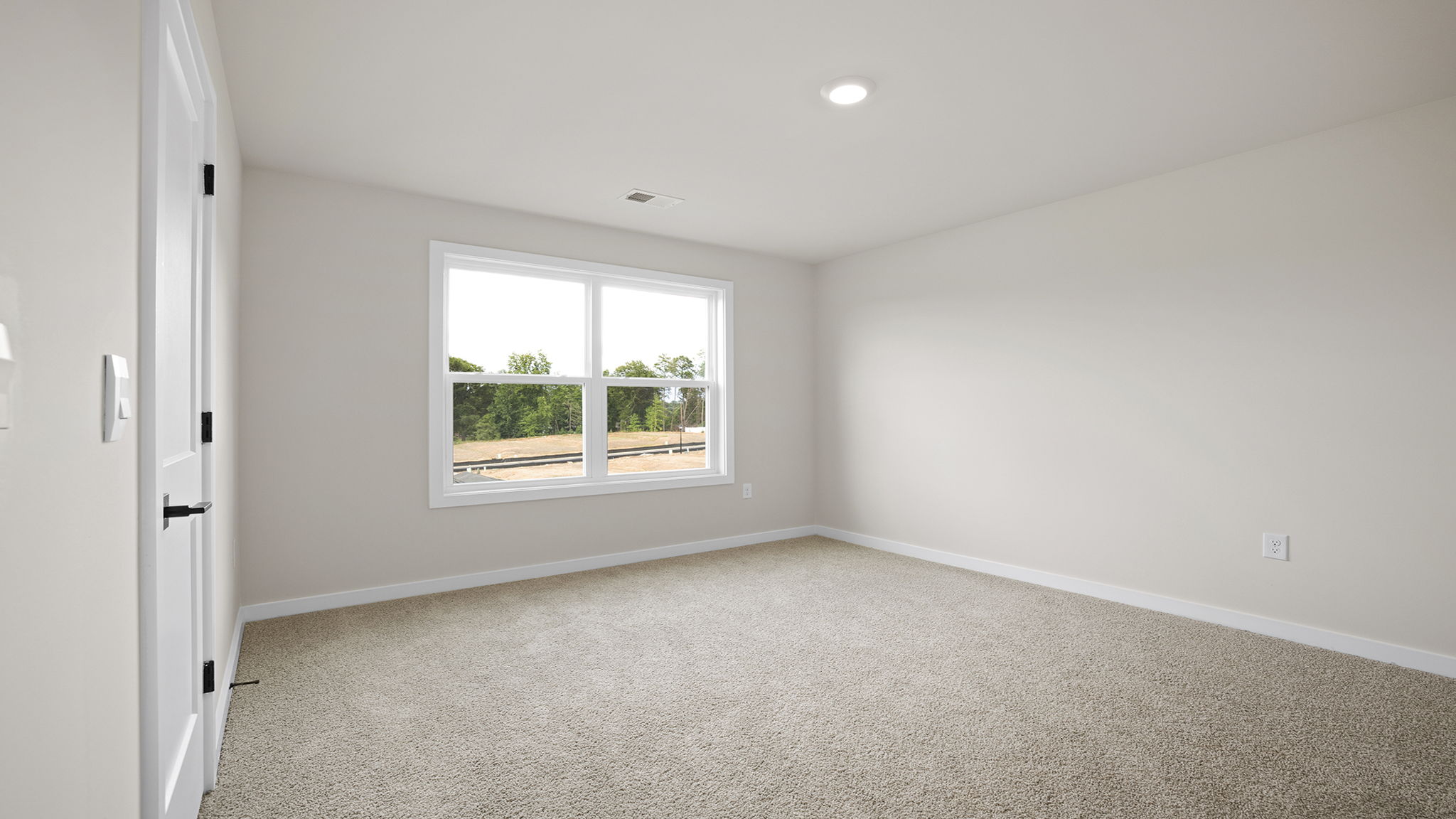 Bedroom with two large windows and carpet.
