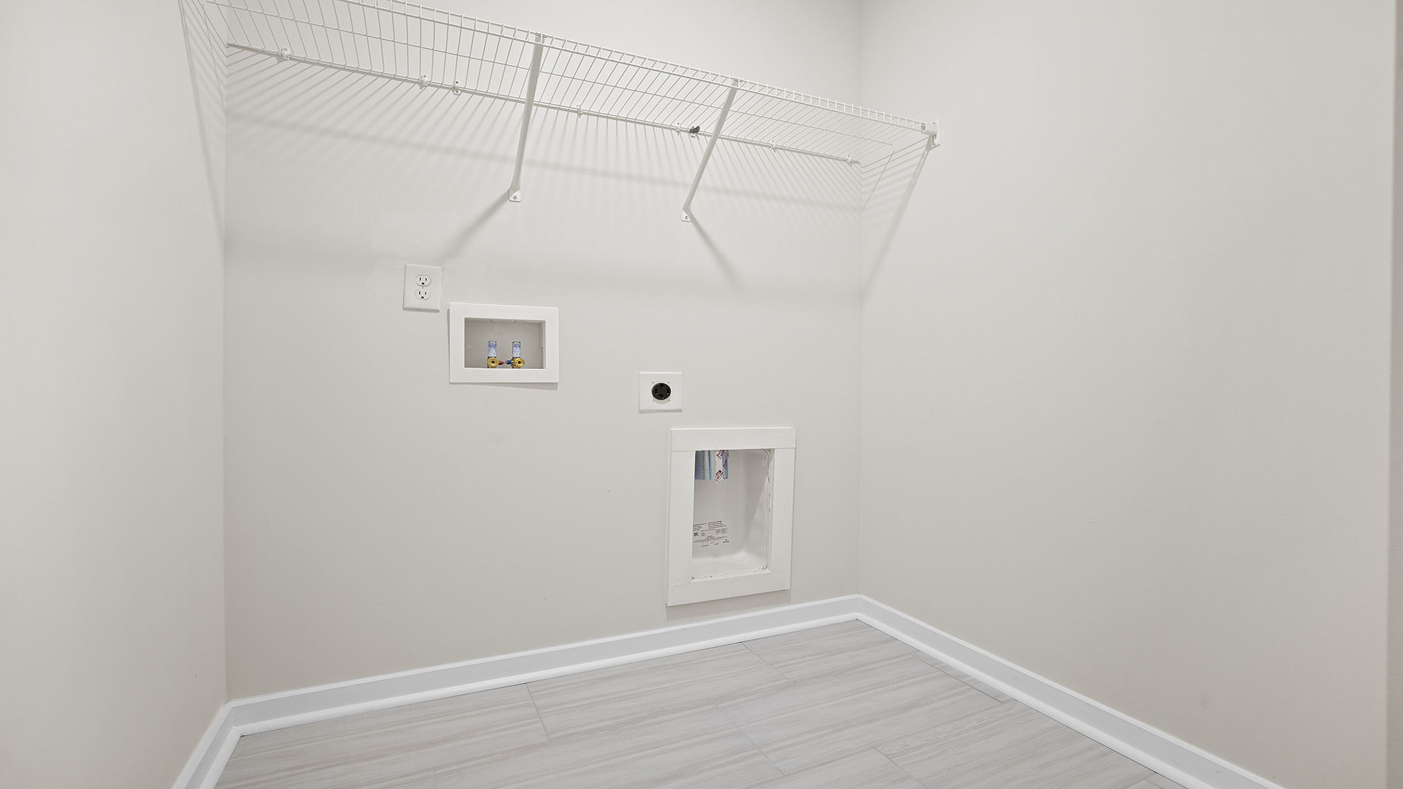 Walk-in laundry room with shelving.
