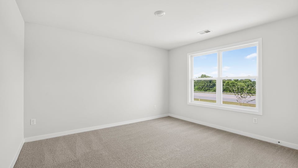 Bedroom with window and carpet.
