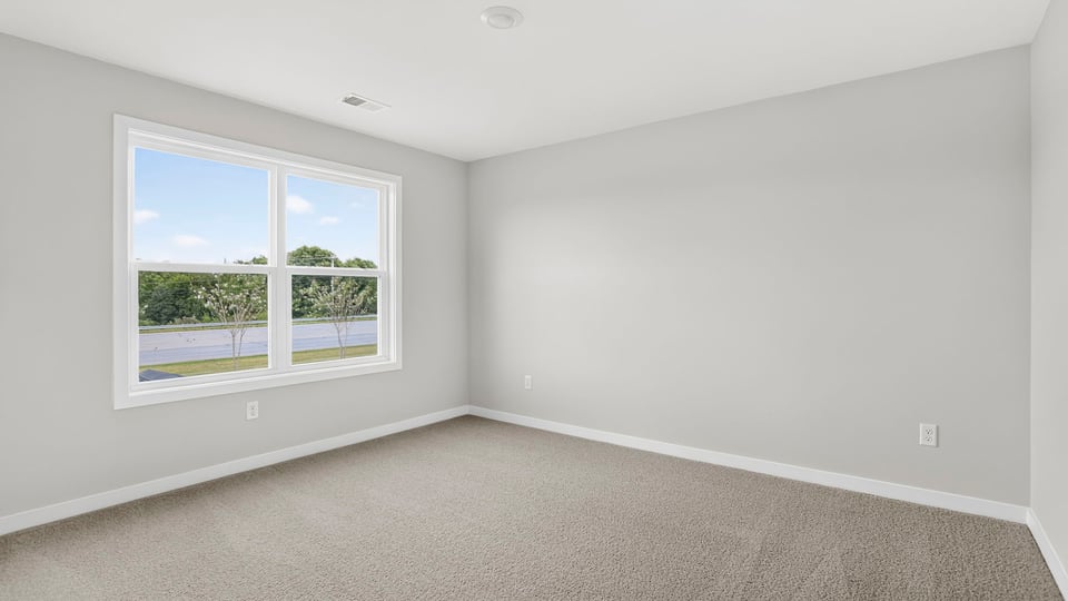 Bedroom with window and carpet.