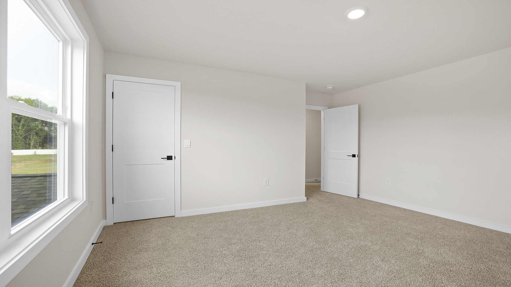 Bedroom with carpet and window.