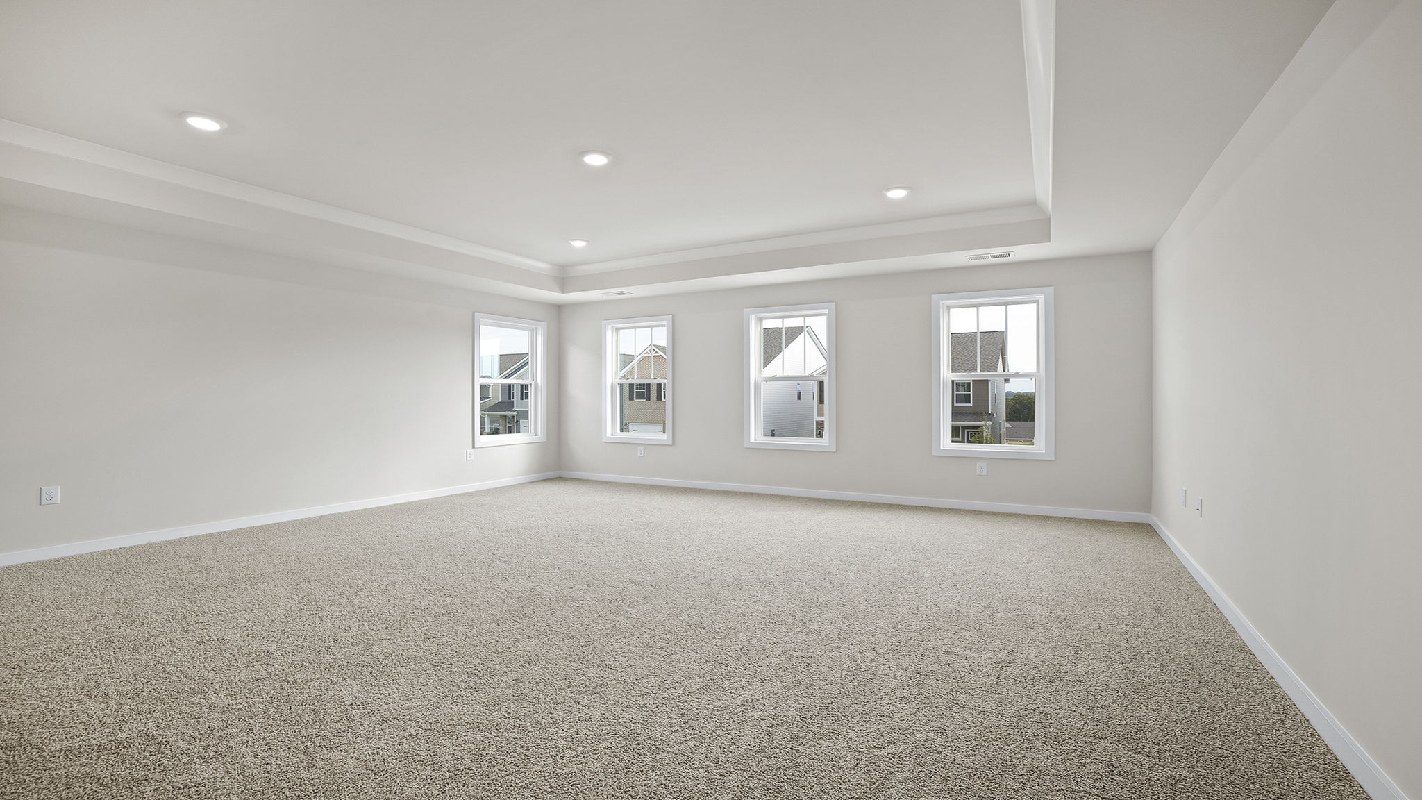 Primary bedroom with carpet and window.
