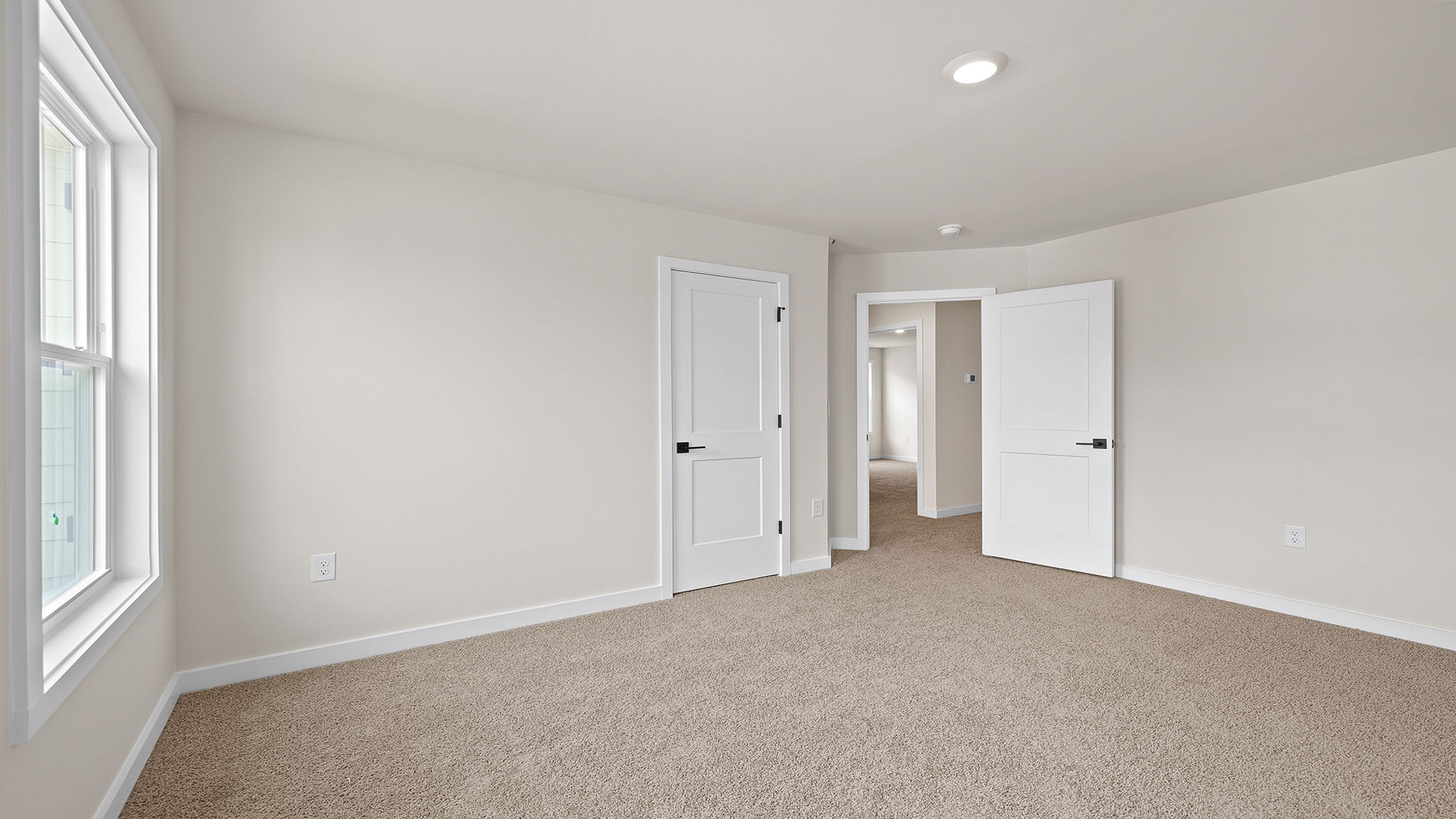 Bedroom with carpet with window.