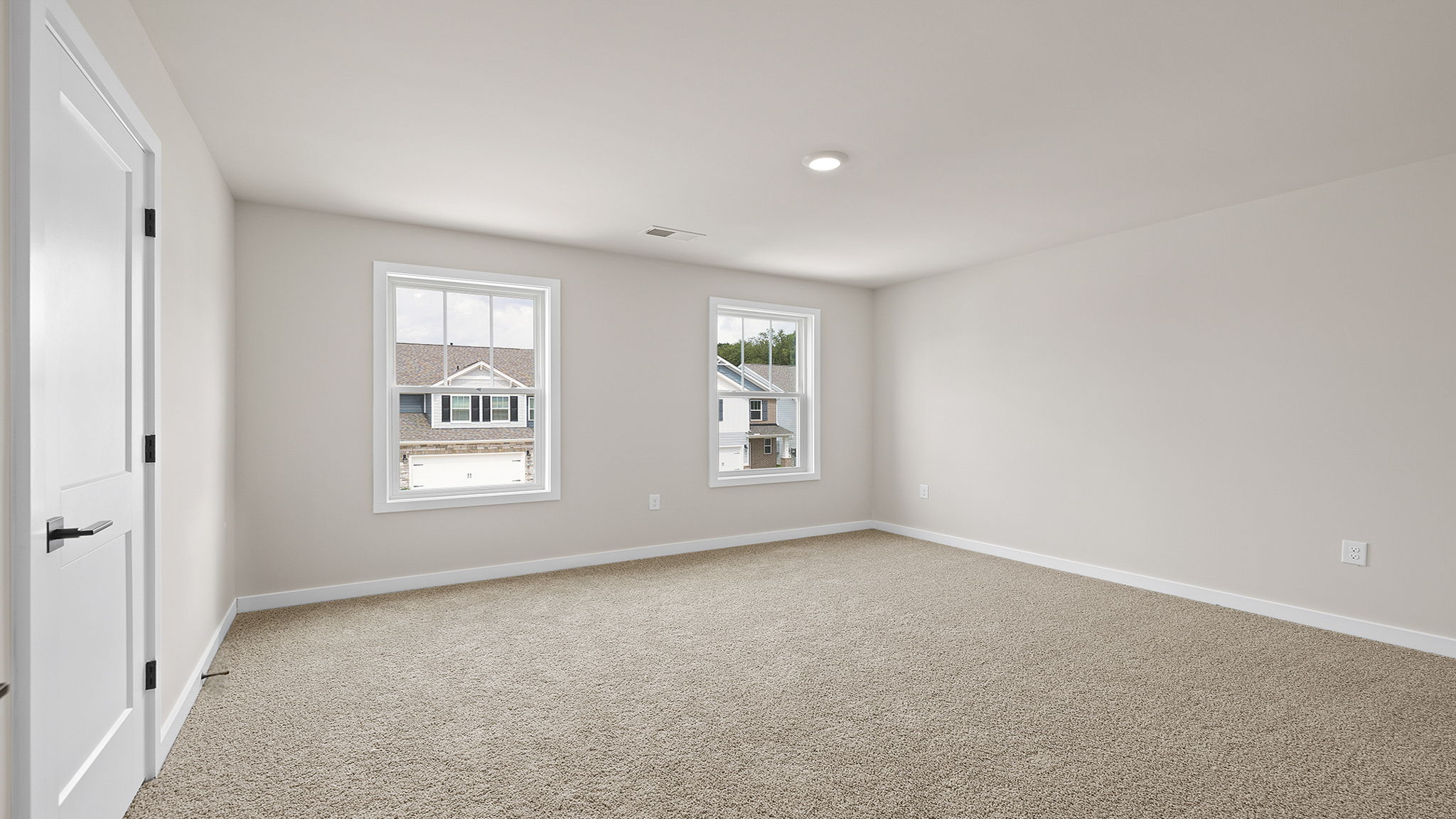 Bedroom with carpet and windows.