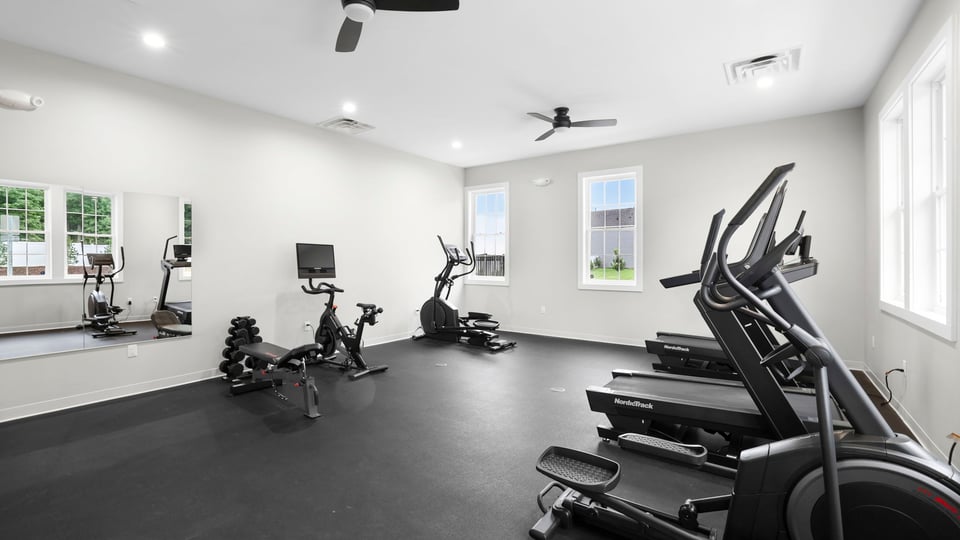 Exercise room in clubhouse with windows.