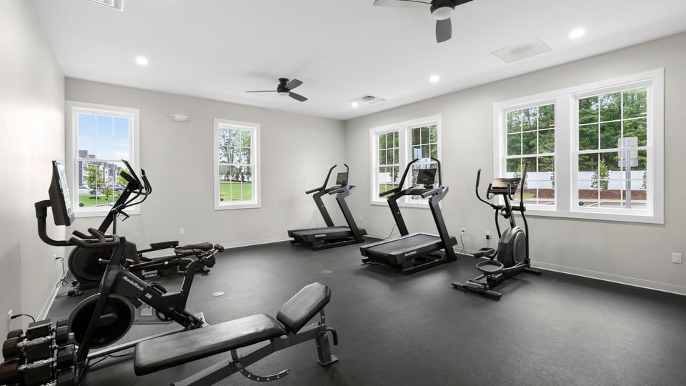Exercise room in clubhouse with windows.