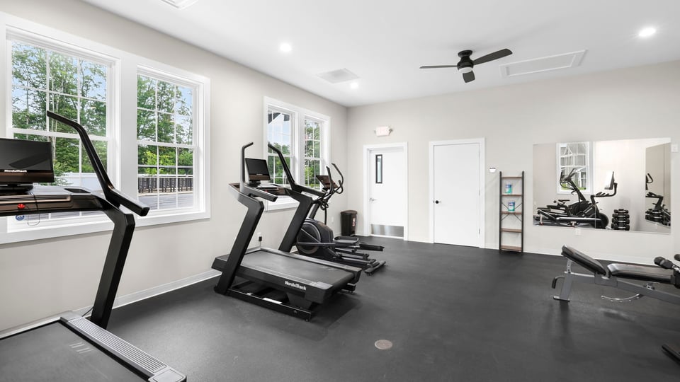 Exercise room in clubhouse with windows.