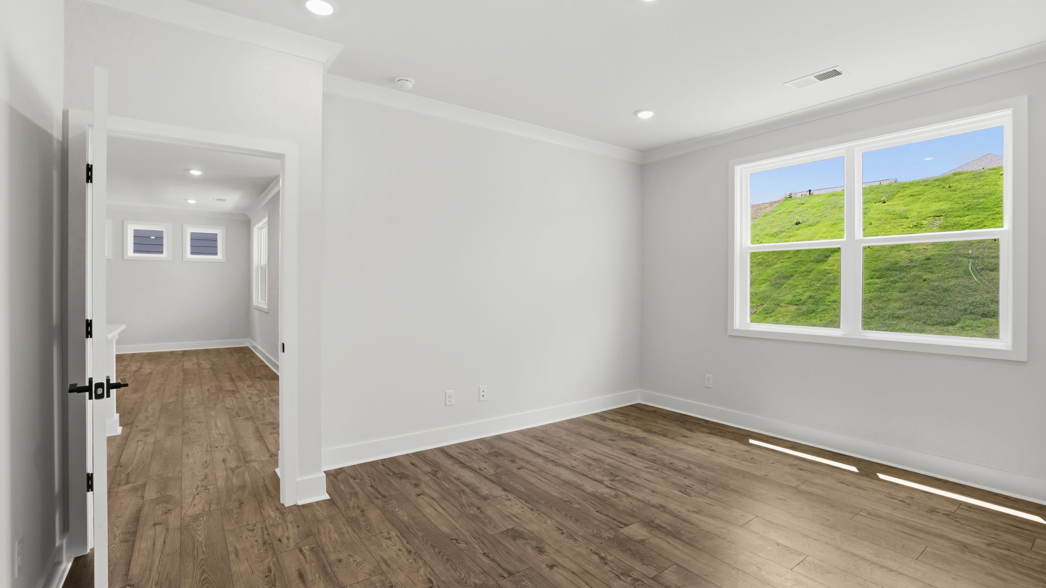 Primary bedroom with carpet and windows.